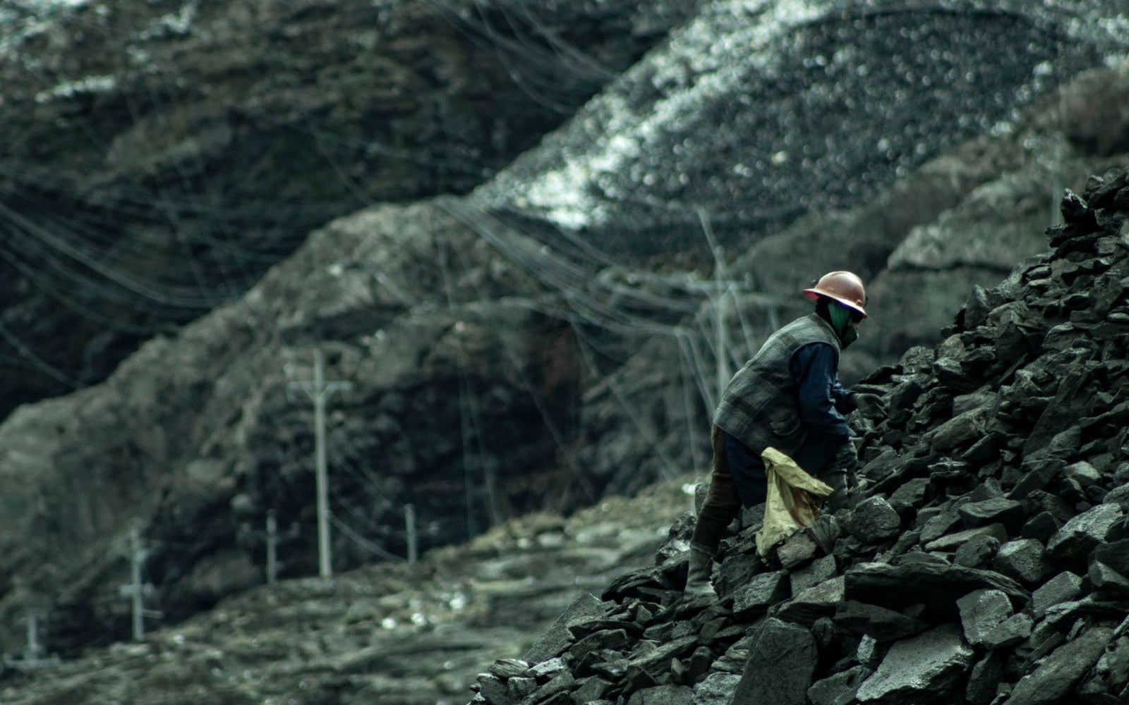Outdoor worker moving across rugged quarry terrain